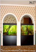 Парные аквариумы встроены в арочные проемы в стене.
