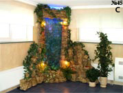 Угловой водопад, представляющий из себя водяную панель с декоративной подсветкой, декорированную искусственными растениями.