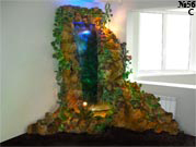 Декоративный водопад в виде водной панели из гнутого акрилового стекла. В нижнем аквариуме живет красноухая тропическая черепаха.